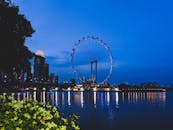 黄昏时分，新加坡城市天际线的灯光倒映在水面上