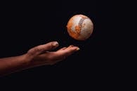 Photo of Person's Hand Throwing a Baseball