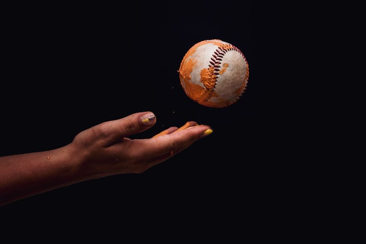 Photo Of Person's Hand Throwing A Baseball