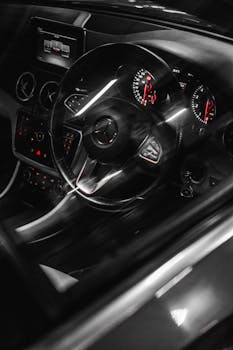 现代梅赛德斯-奔驰汽车内饰特写，展现了仪表盘和方向盘在豪华环境中的细节