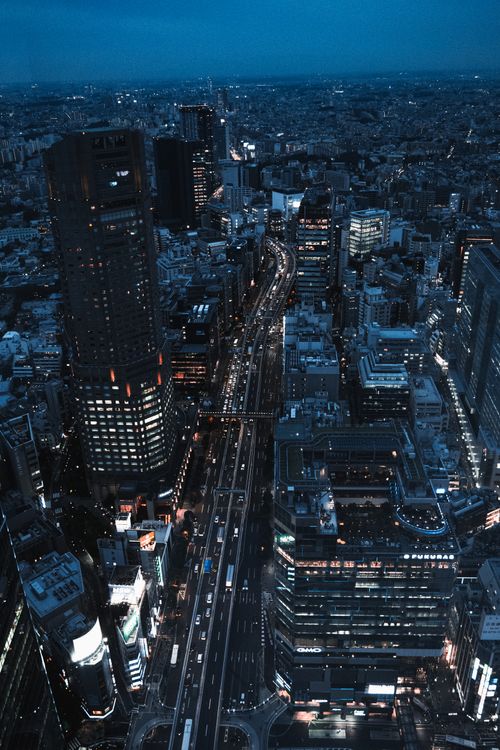 Free Dramatic aerial view of Tokyo cityscape at night, highlighting skyscrapers and bustling streets. Stock Photo