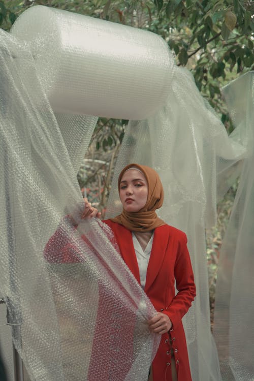 Foto De Mulher Usando Hijab Enquanto Está Perto De Plástico Bolha Pendurado