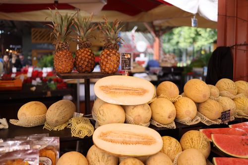 Free Vibrant display of melons and pineapples at an outdoor market stall, highlighting fresh produce. Stock Photo
