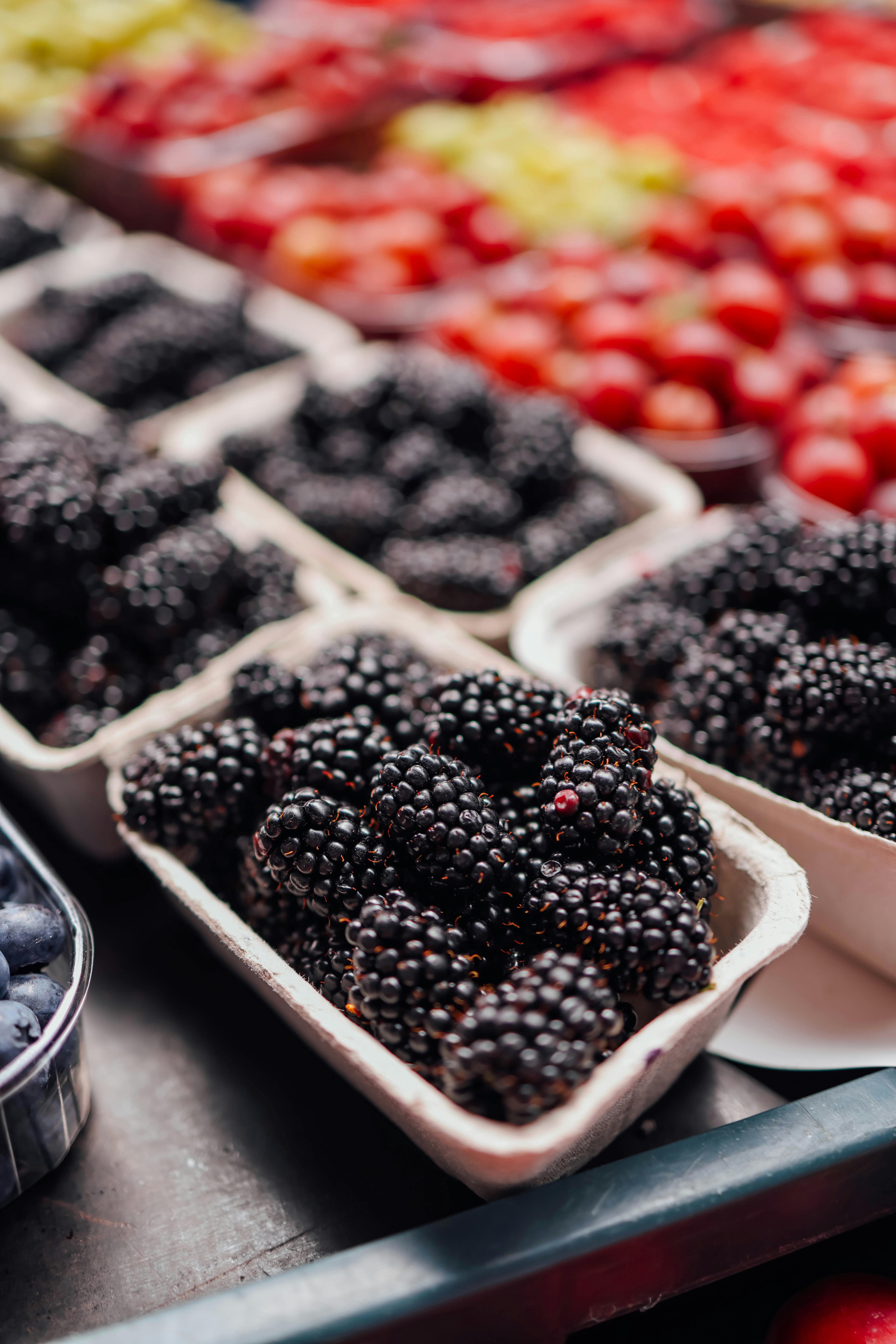 Blackberries and other fruits are displayed in baskets