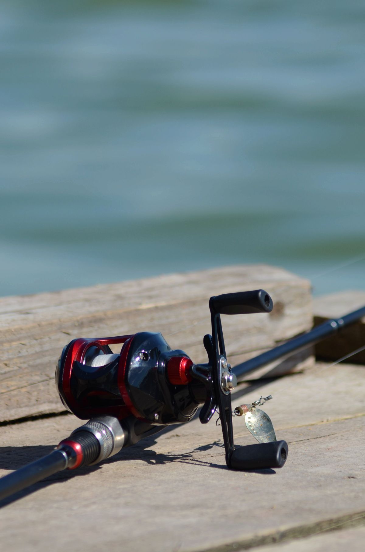 A fishing rod lying along a wooden pier by the river