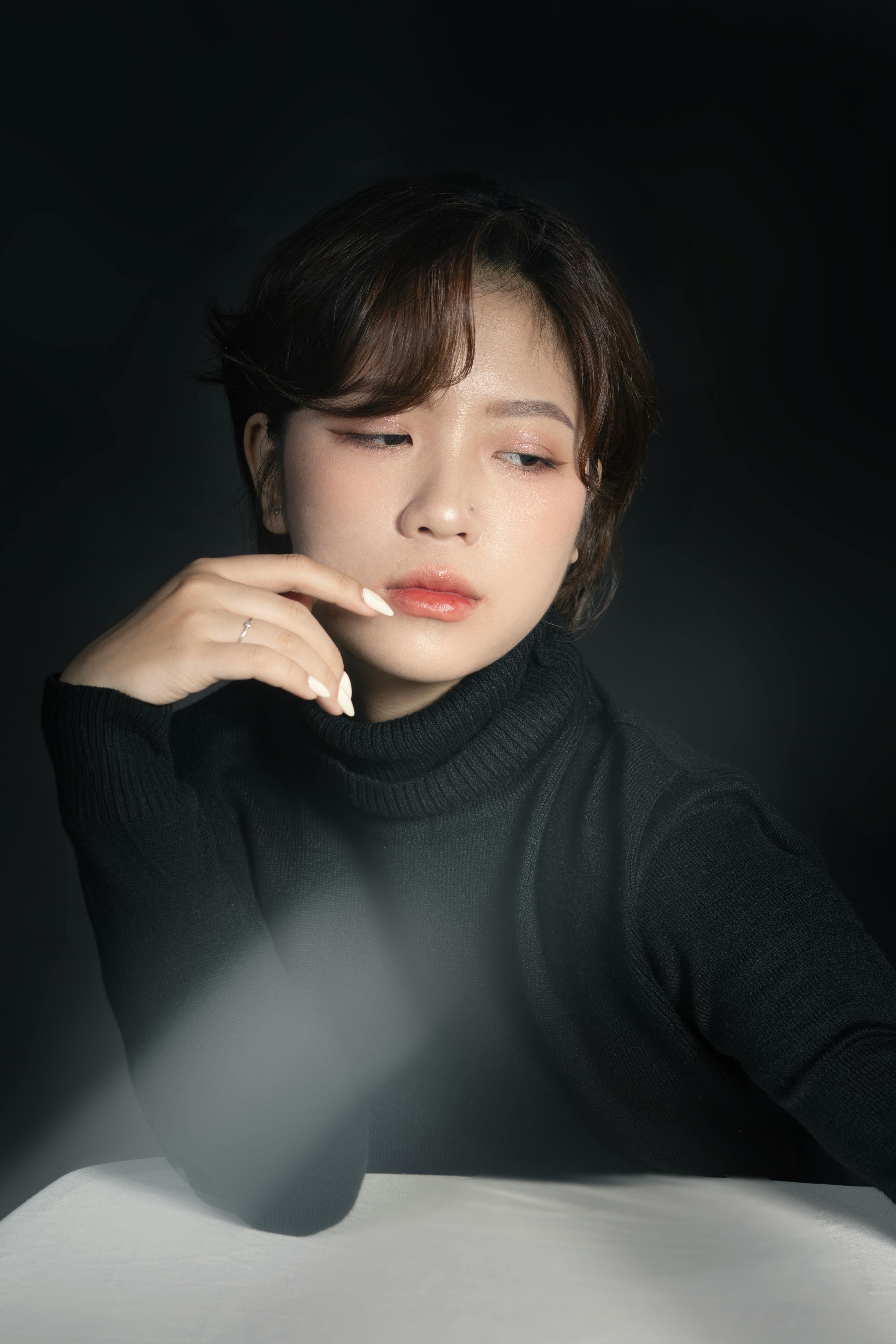 Stylish portrait of a young woman in a black turtleneck, featuring minimalist fashion and neutral to