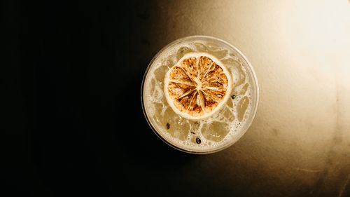 Free Overhead view of a refreshing iced citrus drink with a dried lemon slice, perfect for summer. Stock Photo