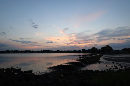 Free Peaceful twilight over a lake with stunning reflections and subtle sunset hues. Stock Photo