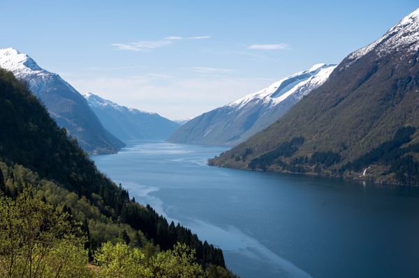 A fjord below snow-capped mountains — photo by Nils R on Pexels