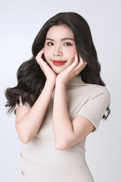 Free Portrait of a young woman with elegant pose on a white background, exuding grace and confidence. Stock Photo