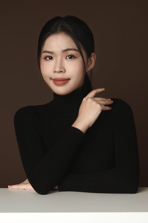 Free Fashionable portrait of an Asian woman posing gracefully in a studio with a neutral background. Stock Photo