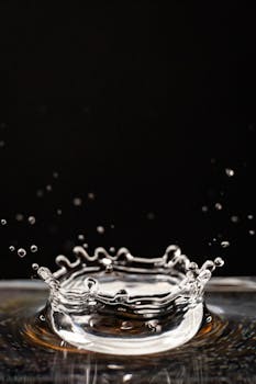 Close-up photo capturing a water droplet splash with ripples against a black background.