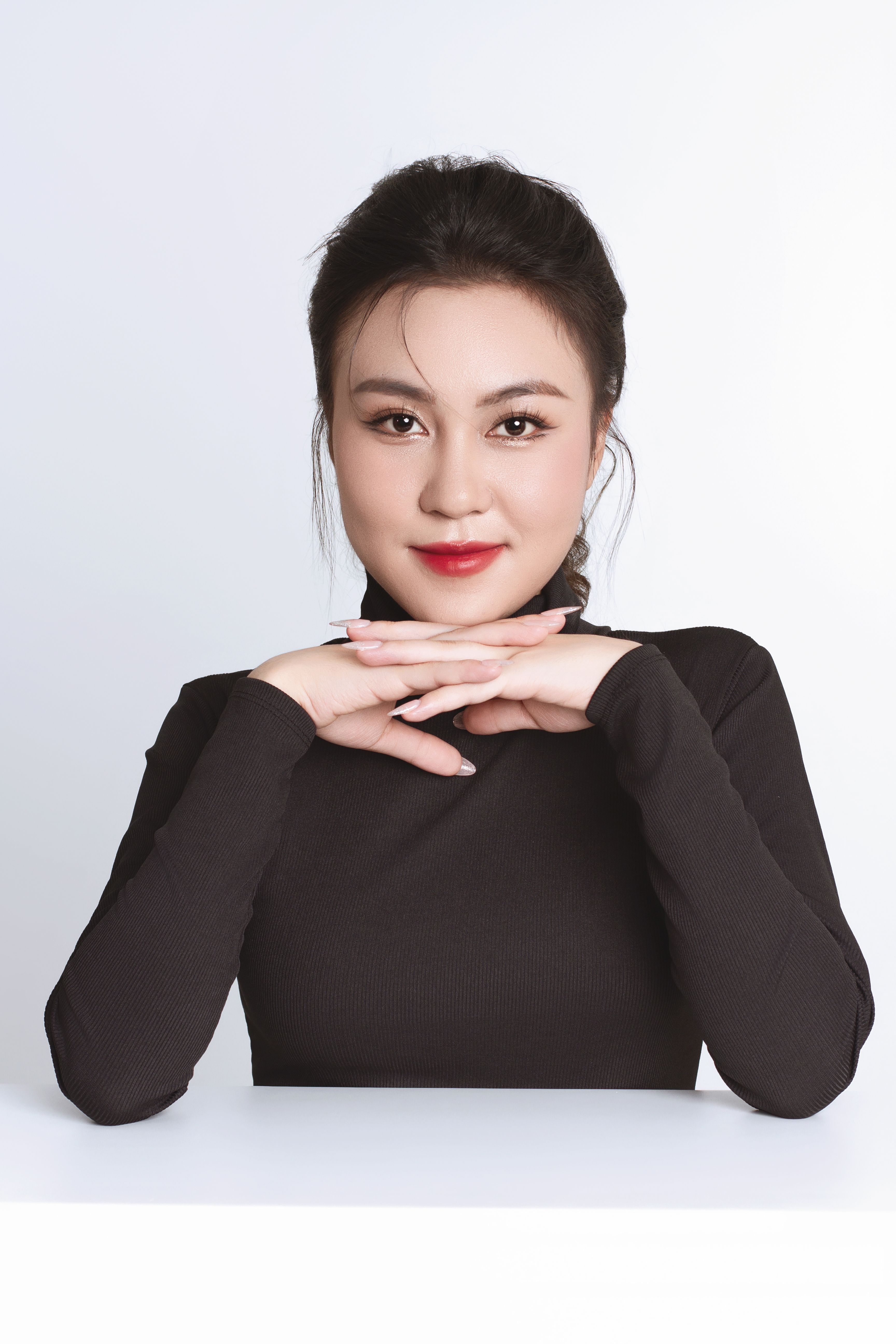 Sophisticated portrait of an Asian businesswoman in a black shirt, posing thoughtfully.