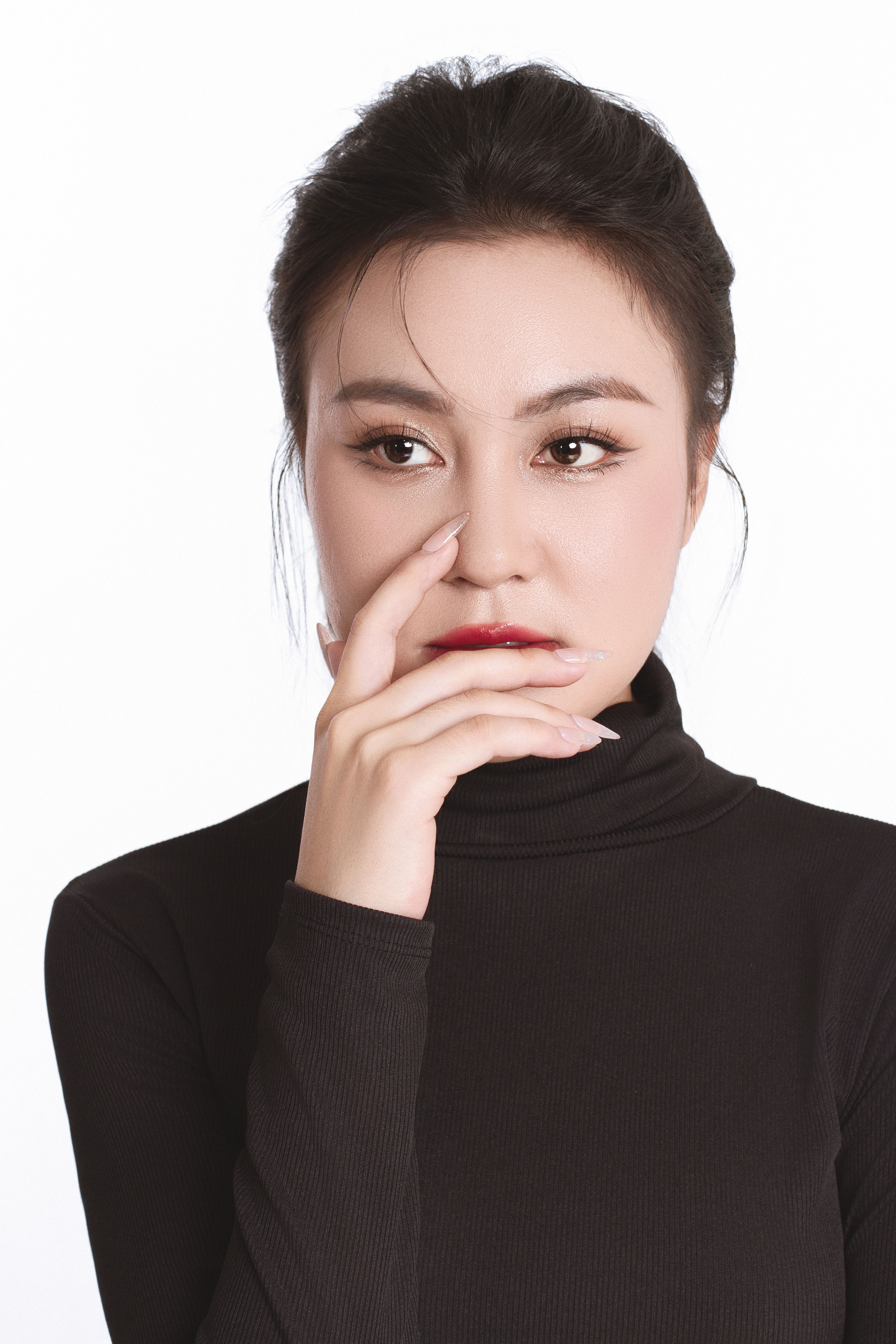 Stylish portrait of a woman in a black turtleneck against a white background.