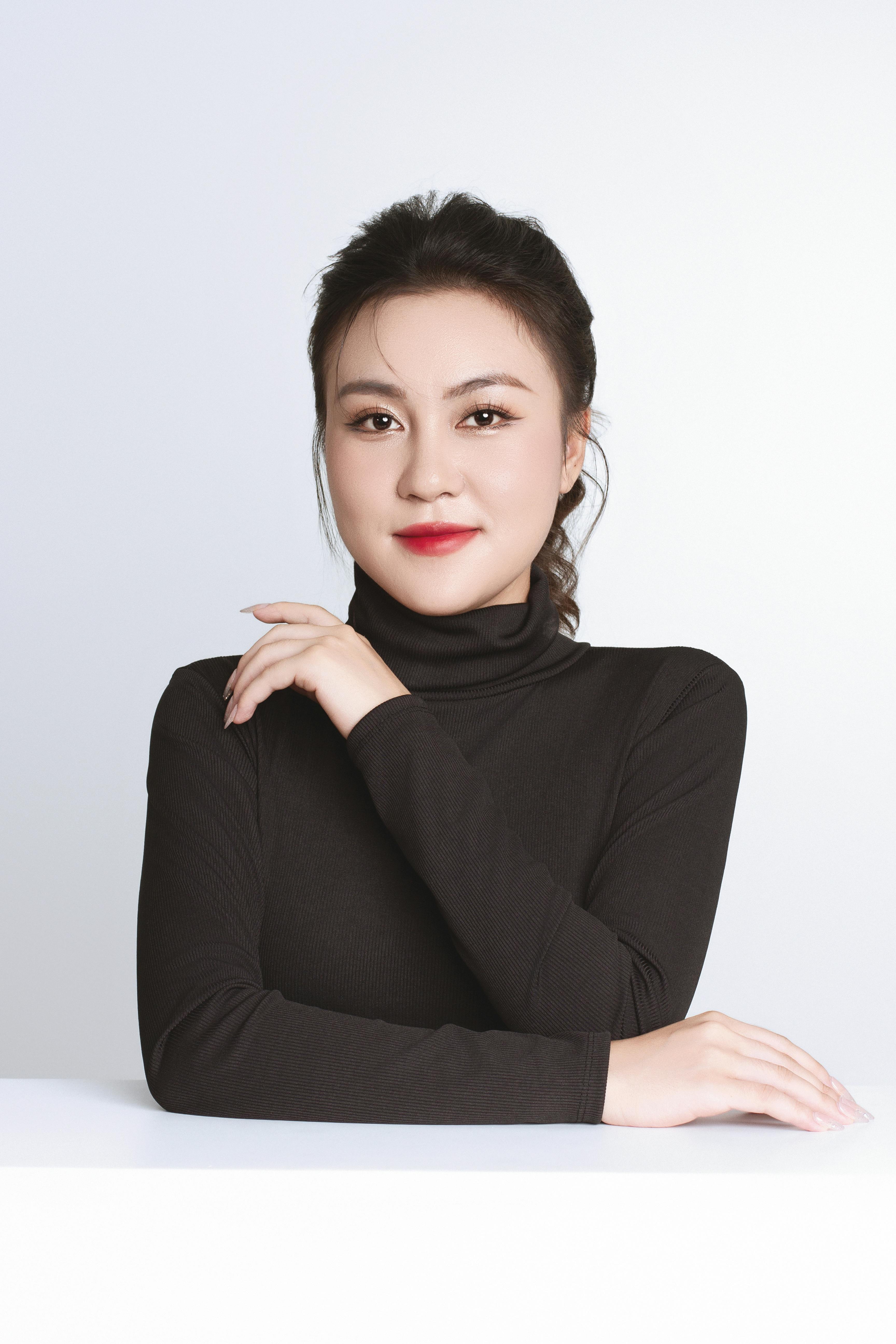 Elegant portrait of a confident Asian businesswoman in a black turtleneck.