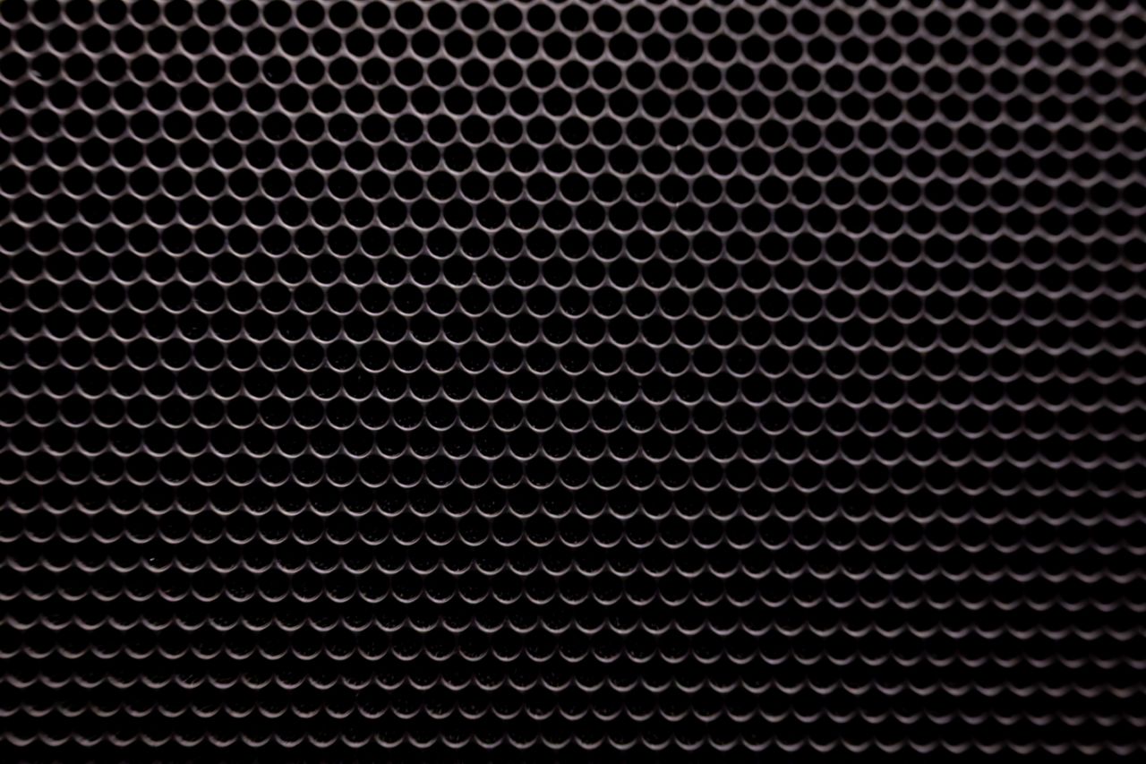 detailed view of a black metallic grid with small circular holes patte