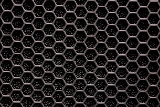 Close-up of a metallic hexagonal grid pattern, resembling a honeycomb structure.