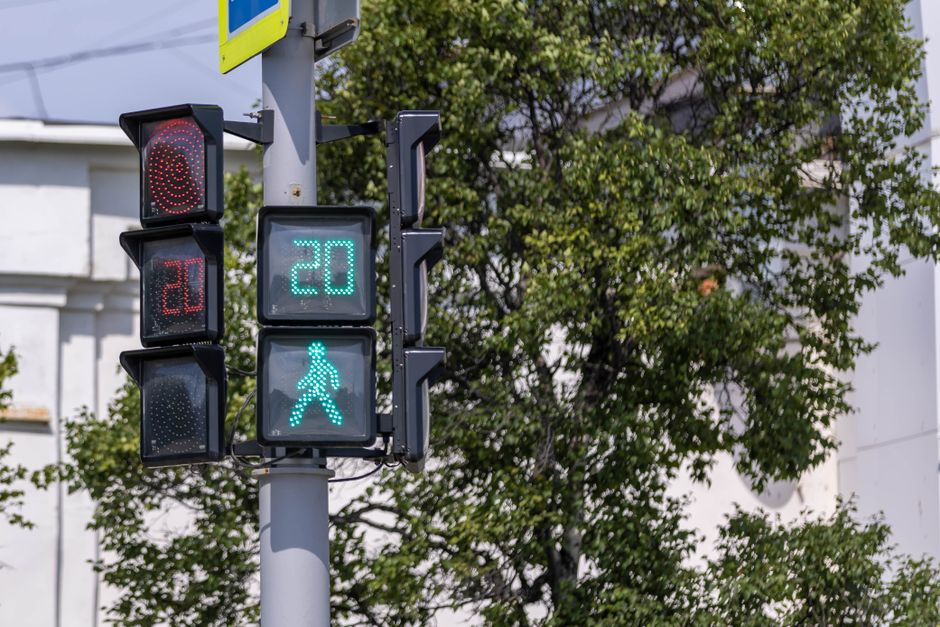 Traffic light with pedestrian countdown timer in a city setting.