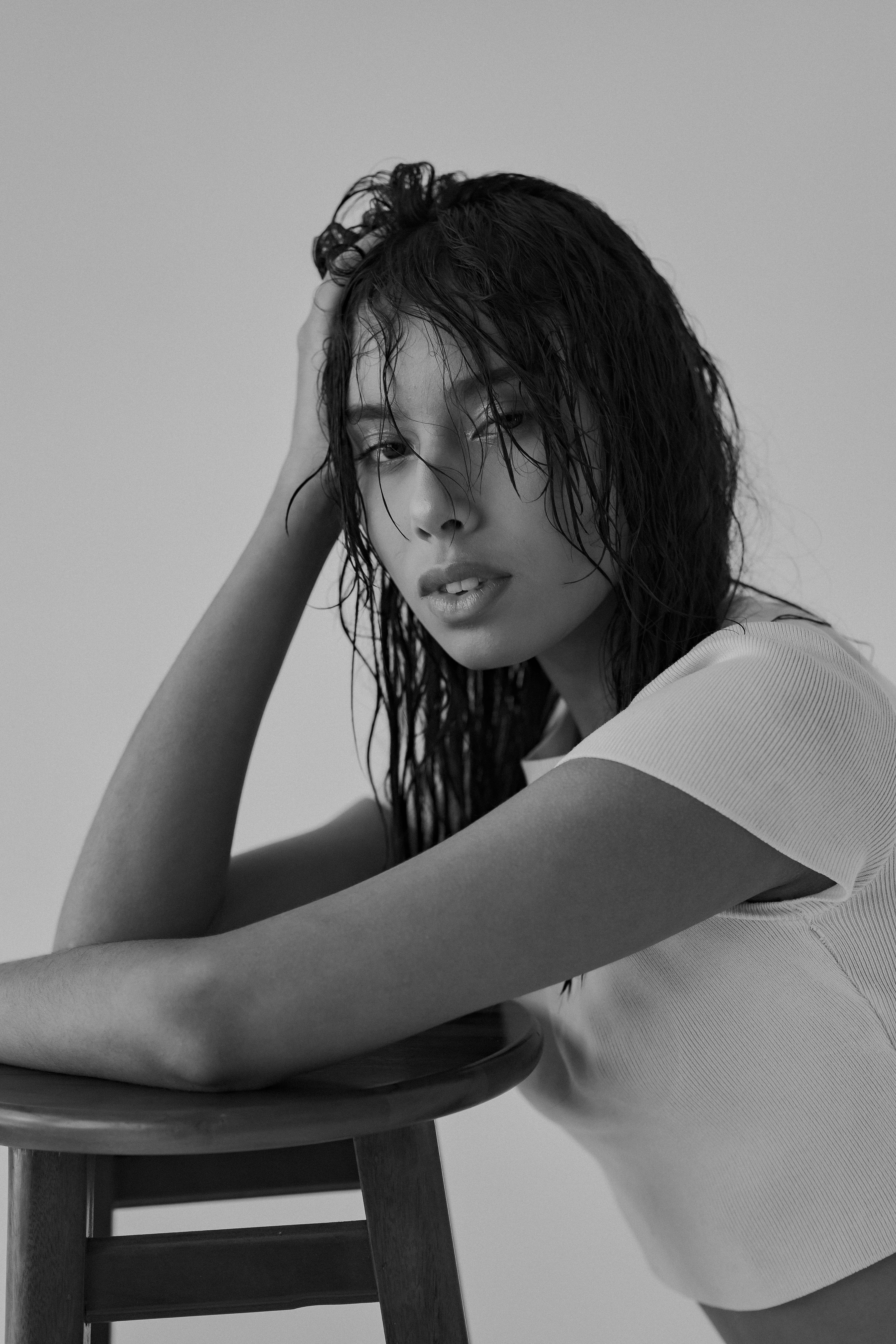 Stylish black and white portrait of a woman posing elegantly indoors.
