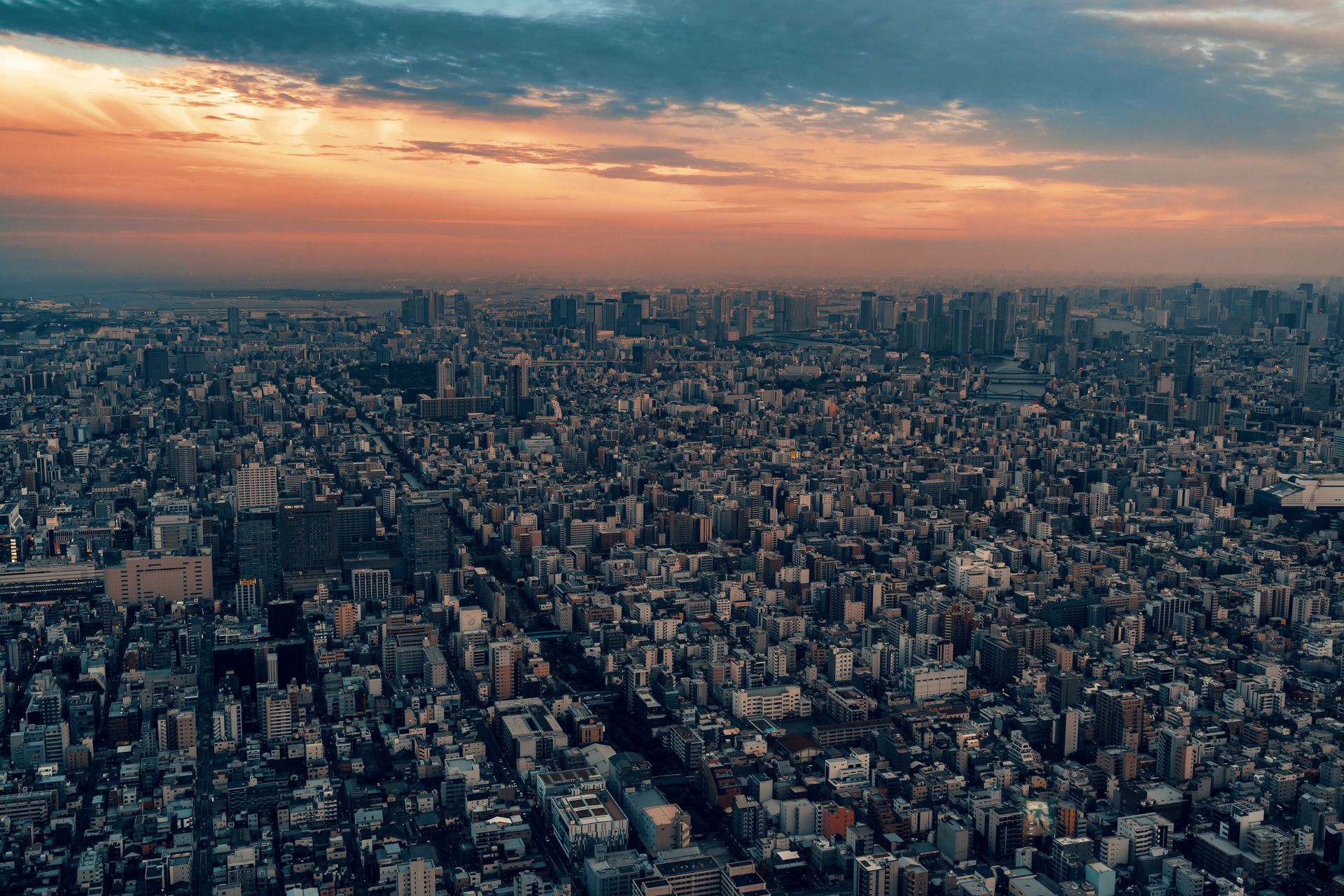 Tokyo financial district skyline at sunset with clouds.