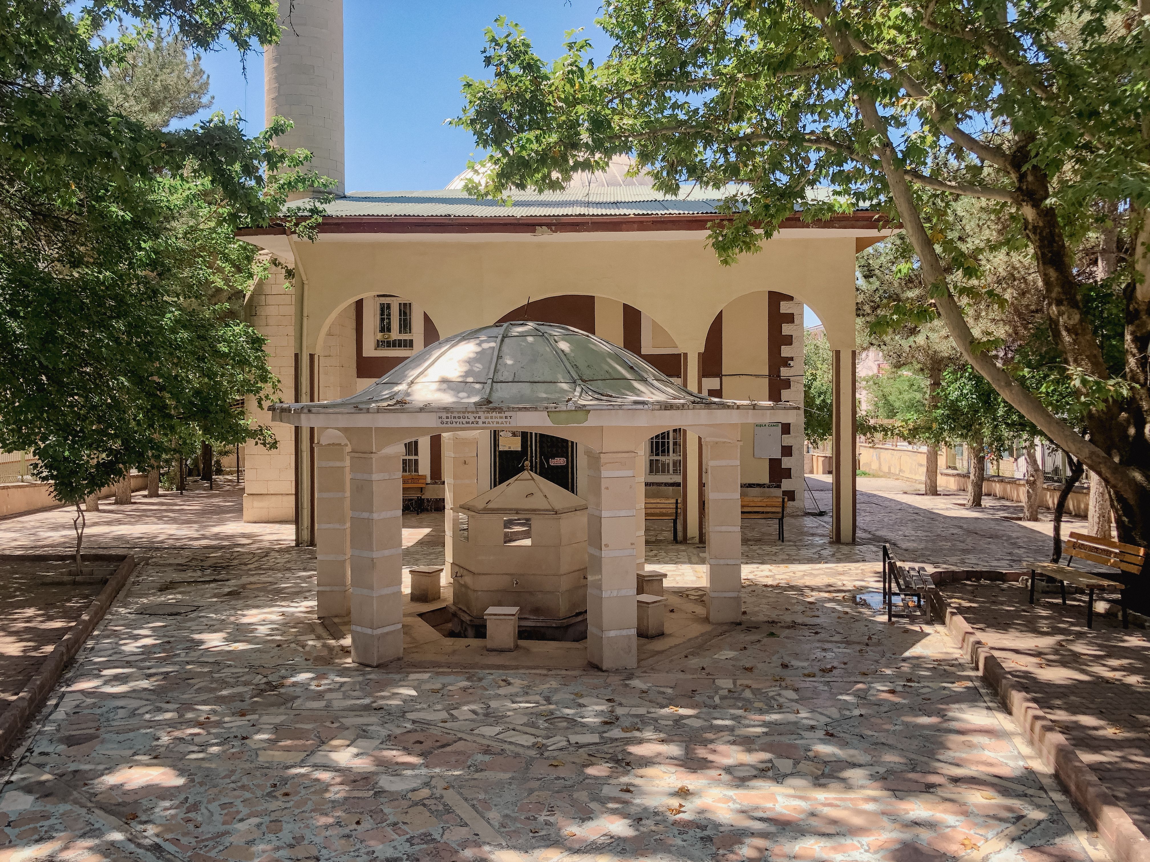 A serene courtyard with a traditional gazebo surrounded by lush trees in Elâzığ, Türkiye.