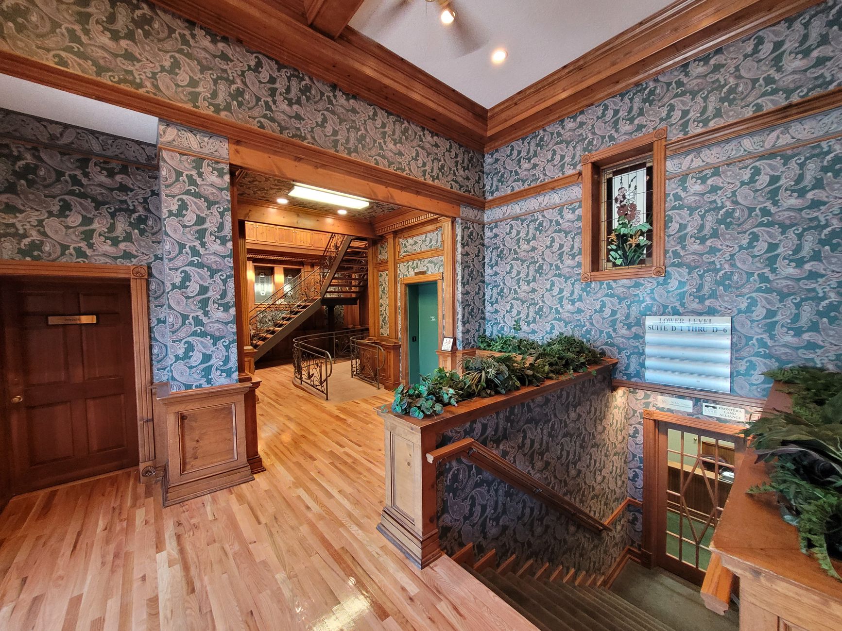 Explore a vintage lobby with classic woodwork and patterned wallpaper.