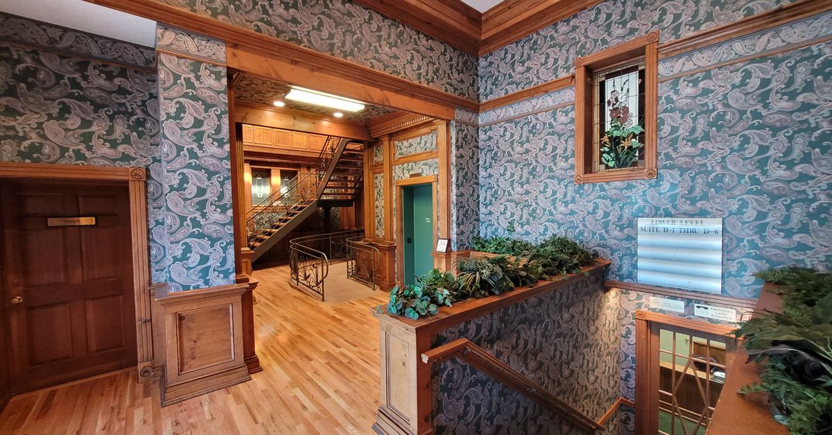 Explore a vintage lobby with classic woodwork and patterned wallpaper.