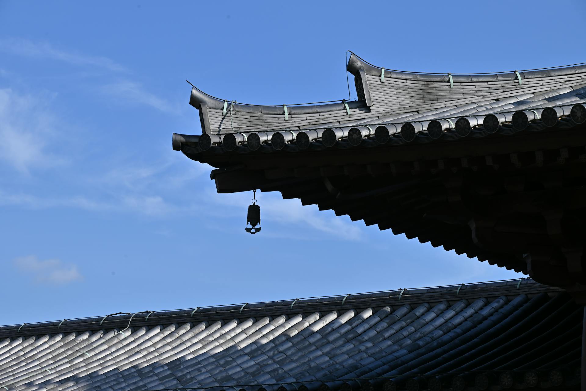 Wind Chime Hanging from a Tiled Roof