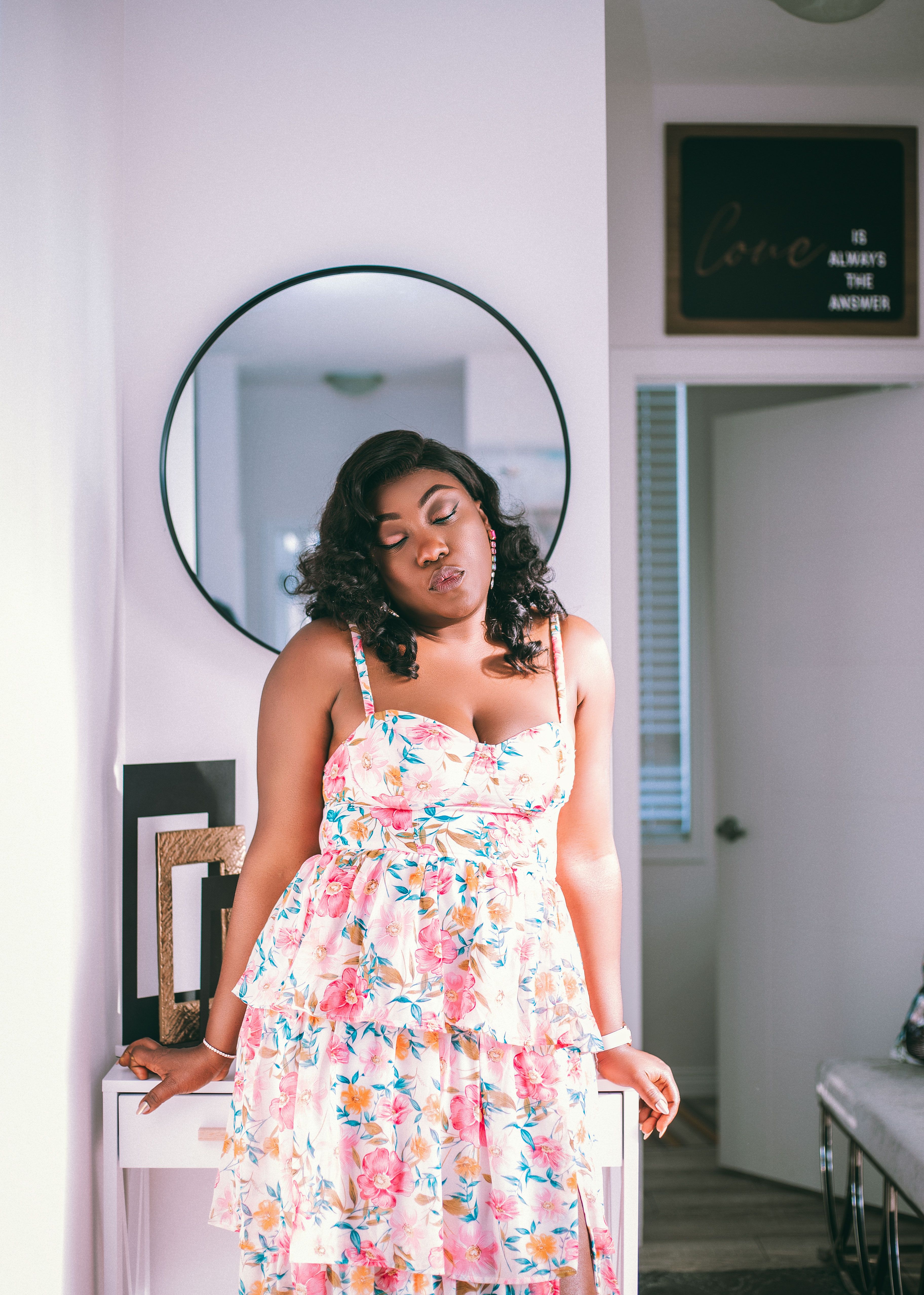 A woman in a floral dress standing in front of a mirror · Free Stock Photo