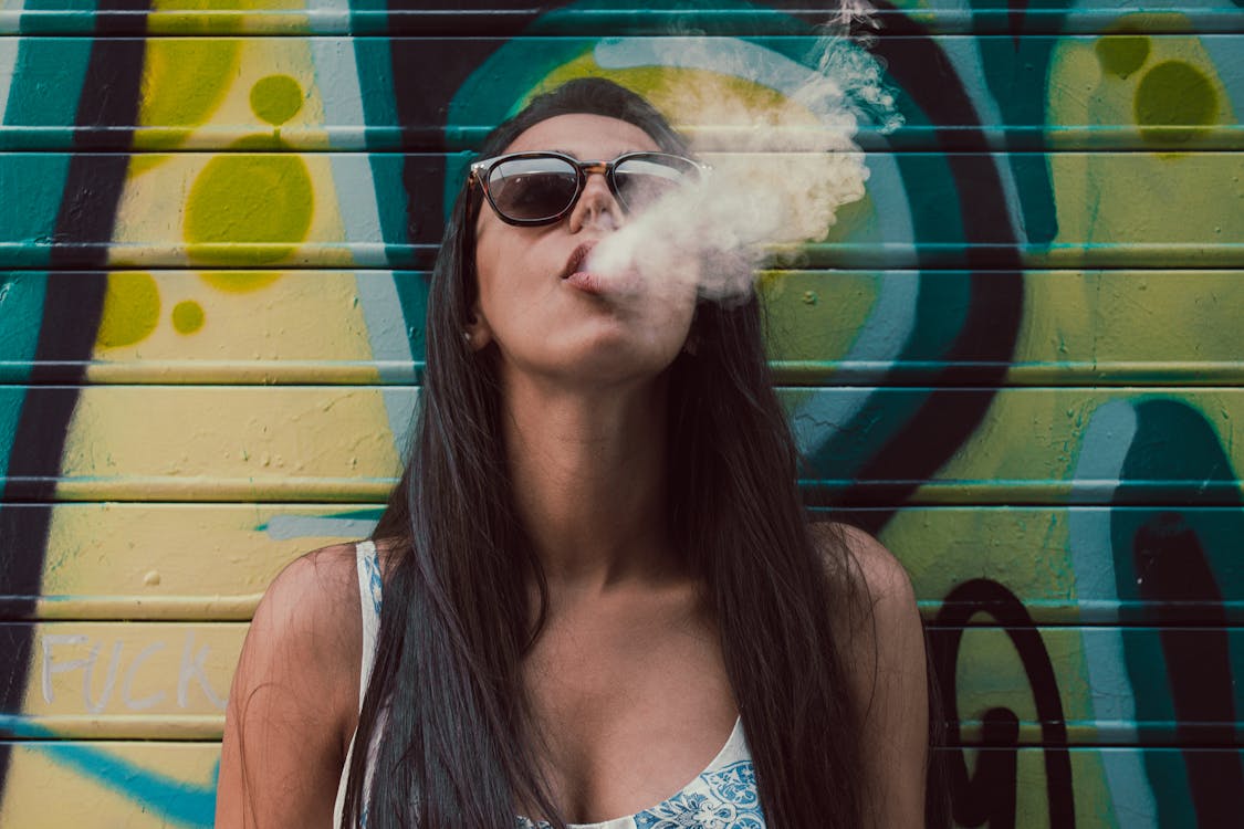 Free Photo of Woman Wearing Sunglasses While Smoking Stock Photo