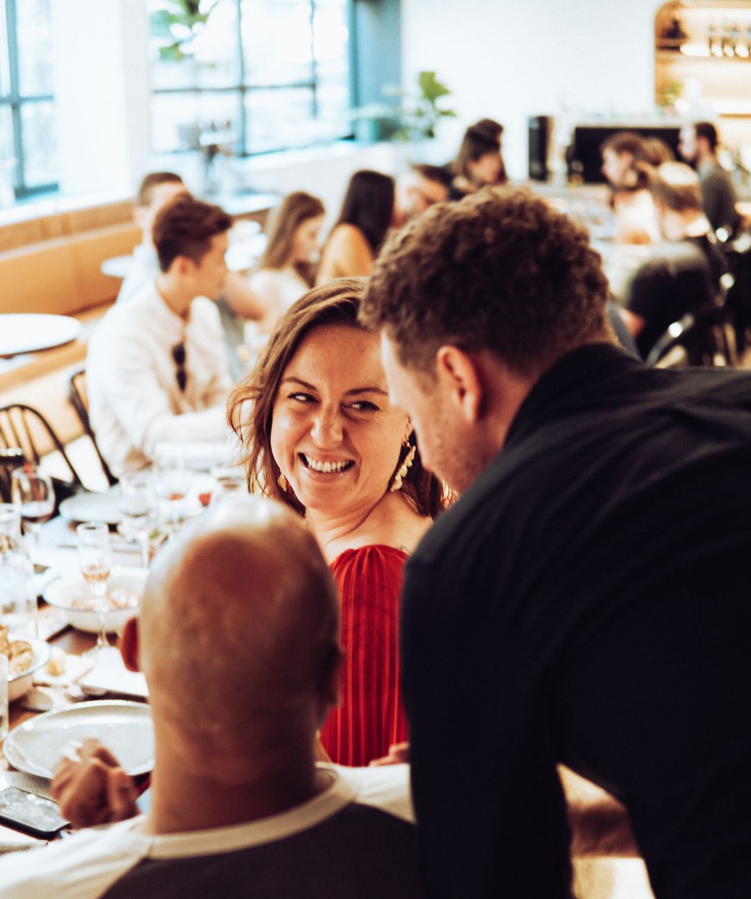 Friends laughing and enjoying a meal together at a restaurant