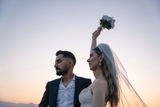 Bride and groom celebrate their sunset wedding with a romantic portrait.