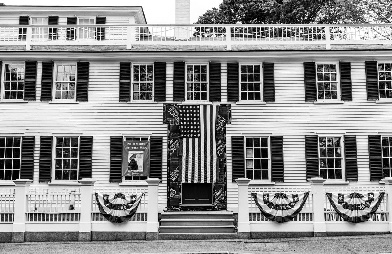 painted-wooden-pallet-flag American flags displayed on a historic building facade