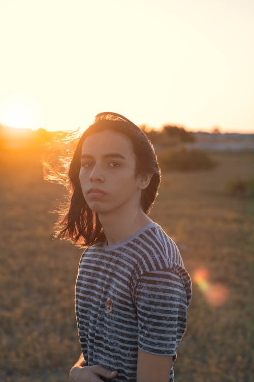 Calm teenager resting in countryside during sunset