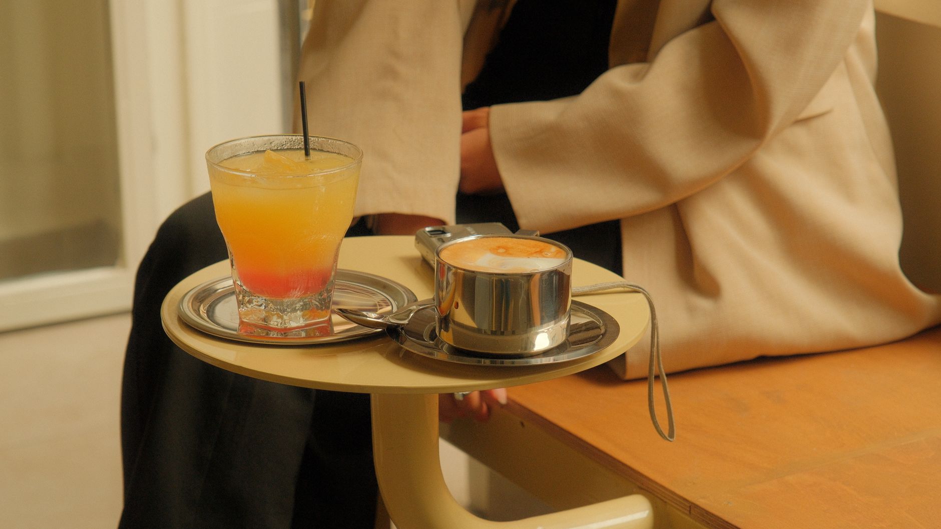 A warm, inviting café scene showing a cocktail and coffee on a table.