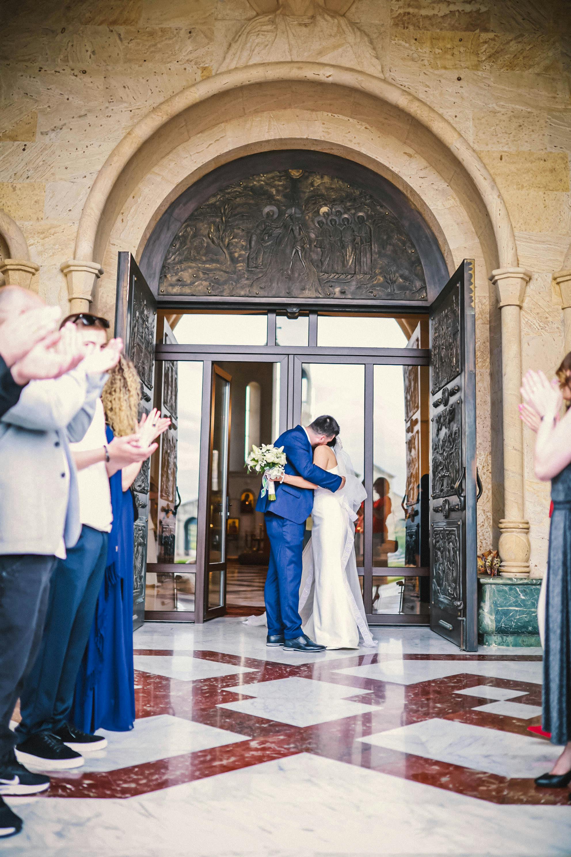 wedding couple kissing in church doorway