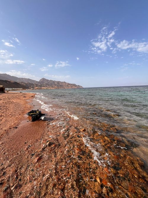 Free Explore a beautiful rocky beach with clear skies and a breathtaking ocean view, perfect for travel enthusiasts. Stock Photo