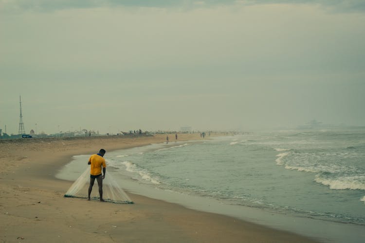 Fisherman With Net On Beach