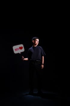 Portrait of a man holding a smartphone with a heart symbol, symbolizing social media interaction.
