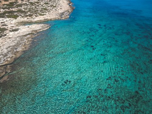Free Stunning aerial view of clear turquoise waters and rocky coastline Stock Photo