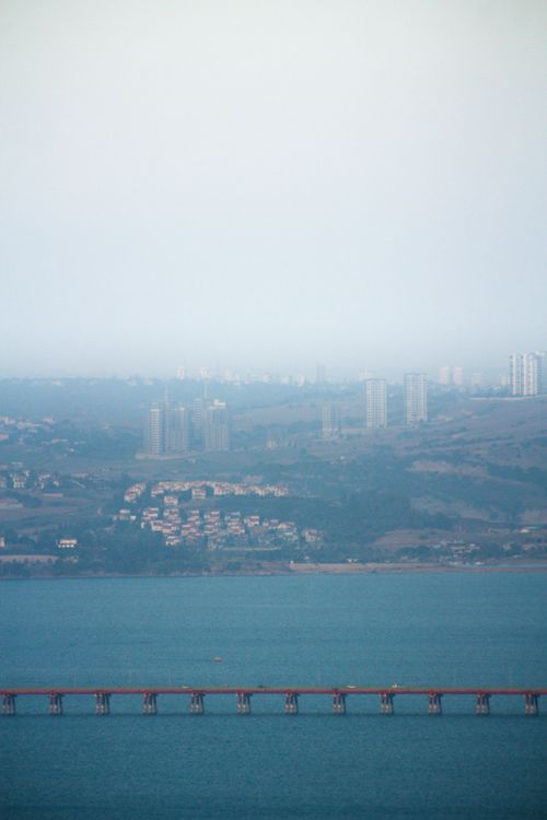 Free Aerial view capturing Adana's city skyline, bridge, and water on a misty day. Stock Photo