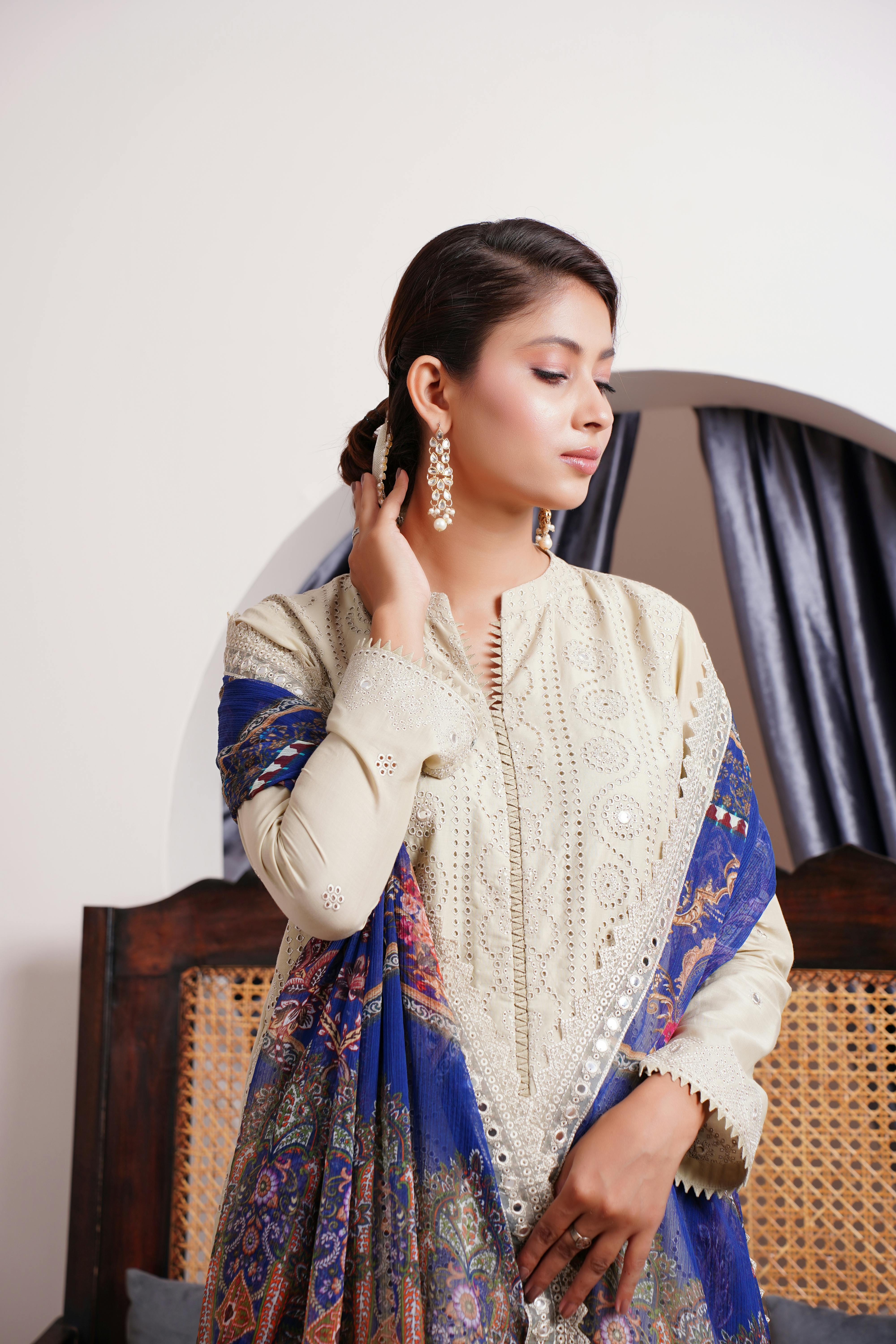 portrait of a pretty brunette wearing a beige dress and a shawl