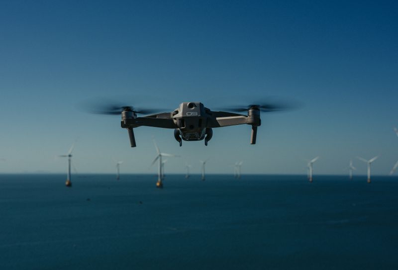 Drone hovering near an offshore wind farm