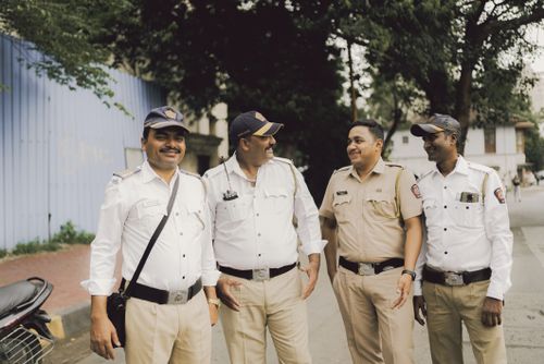 Free A group of friendly police officers smiling and standing on a street in Mumbai, India. Stock Photo