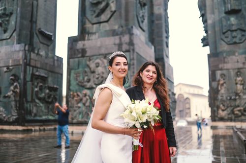 Free Bride and mother posing in elegant wedding attire at iconic monument. Stock Photo