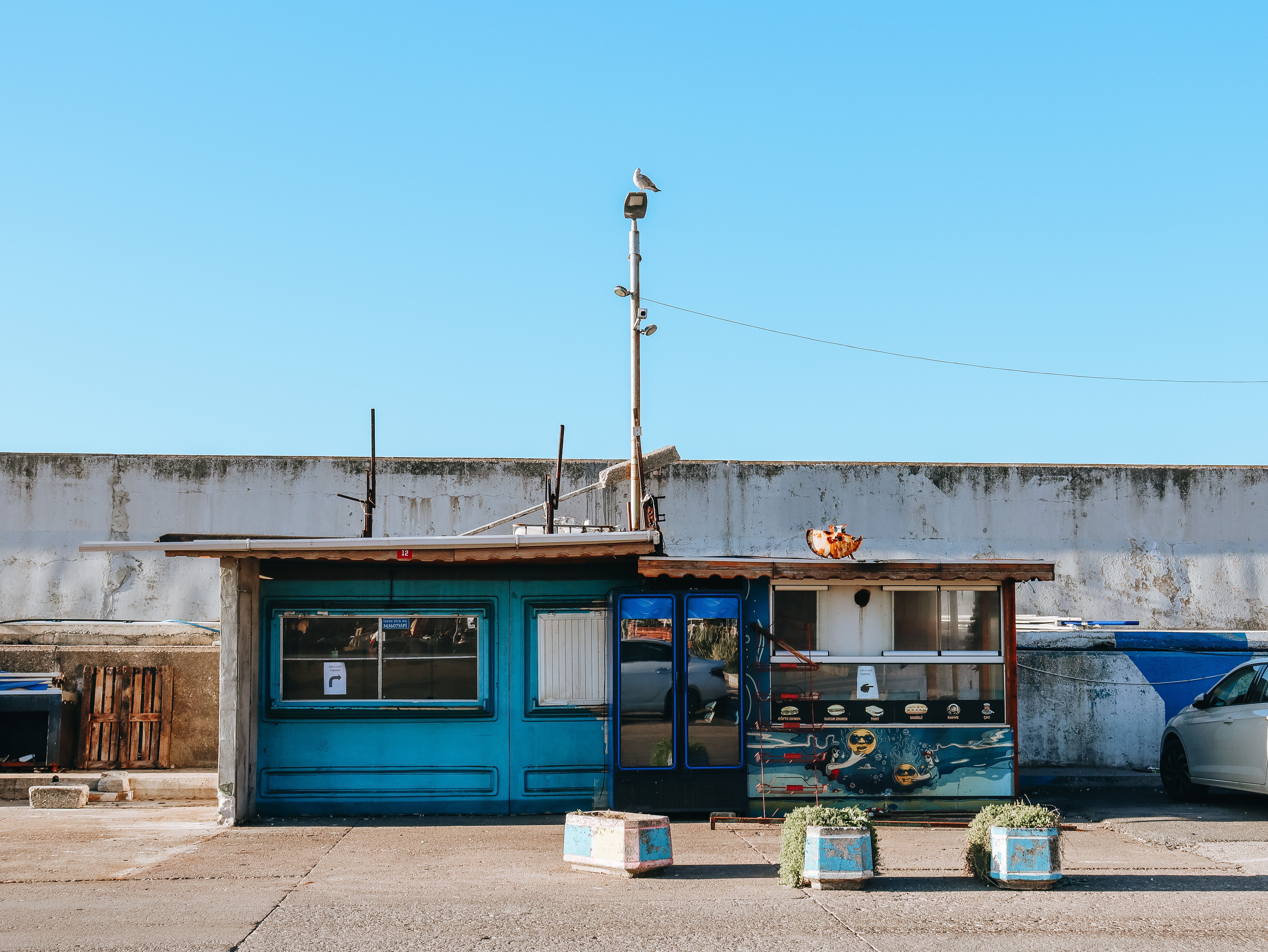 Charming rustic store with vibrant blue facade under a clear sky, evoking urban nostalgia.