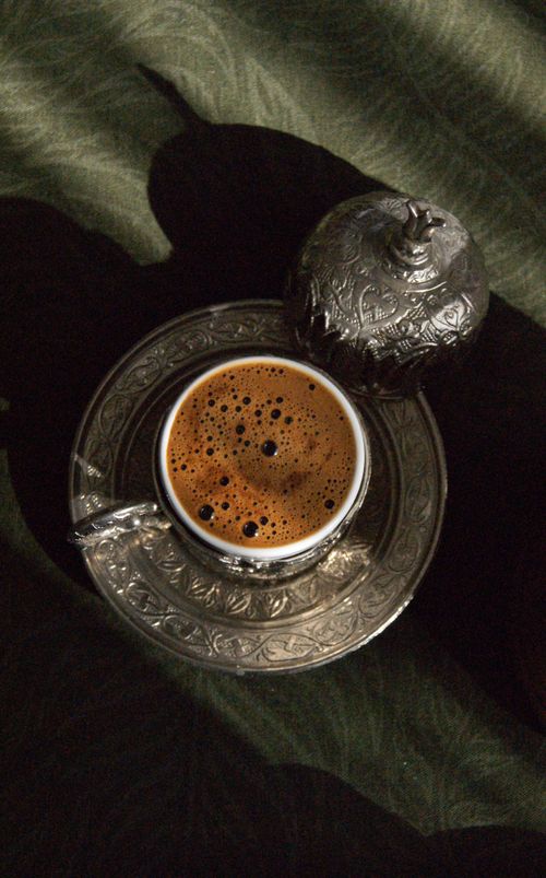Free Close-up of frothy Turkish coffee in an ornate cup on patterned table. Stock Photo