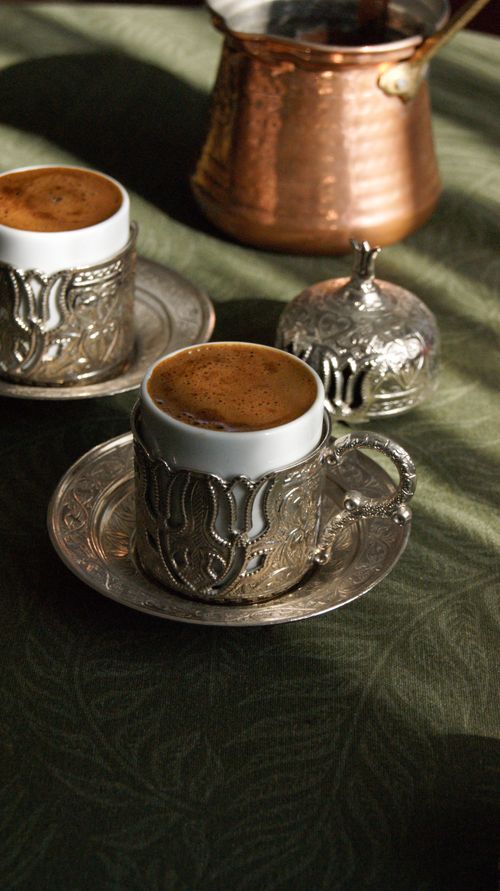 Free Elegant Turkish coffee presentation with decorative metal cups and saucers, reflecting cultural heritage. Stock Photo