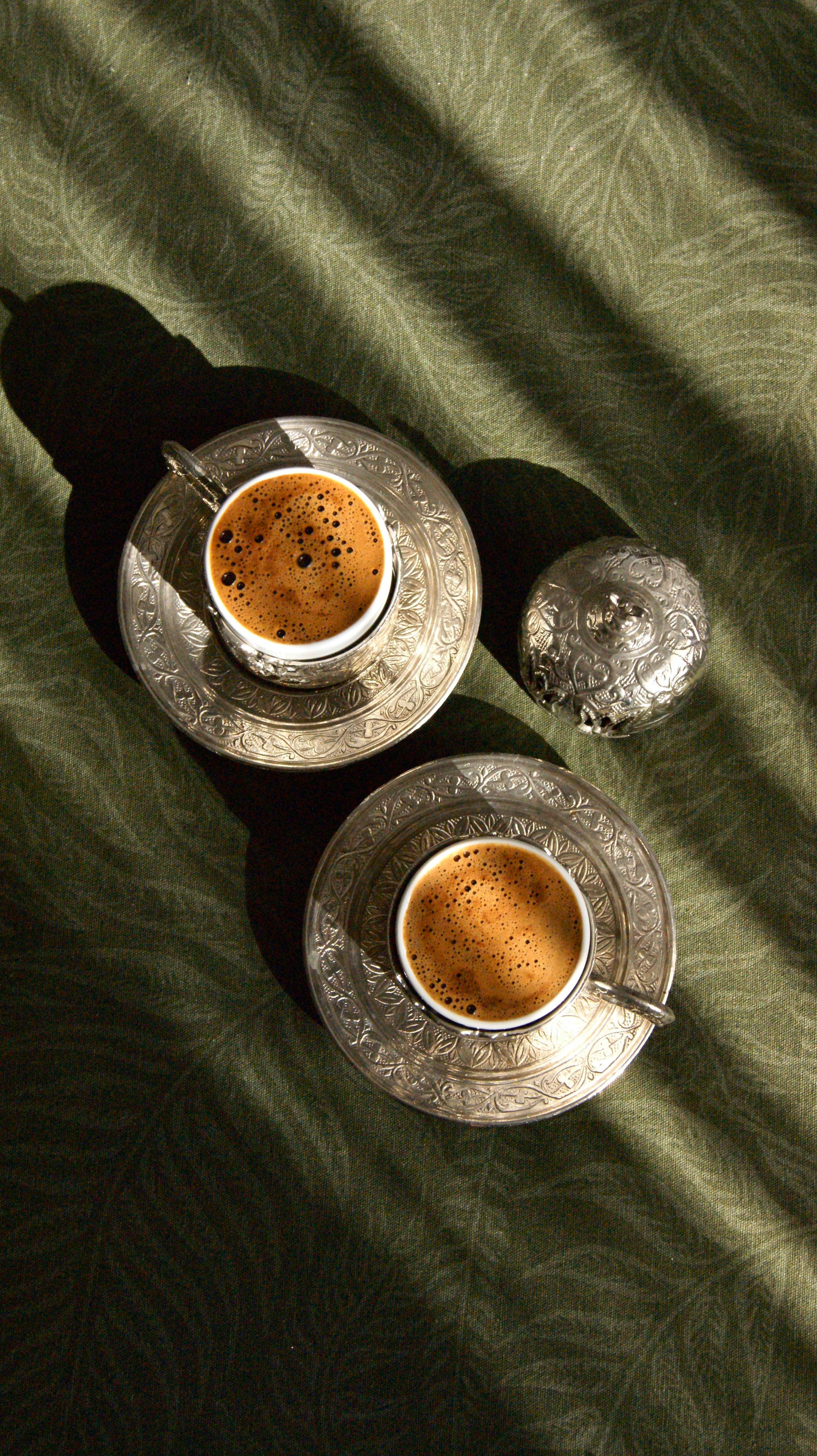 cups of coffee on silver plates