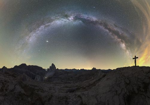 Galaxy over Rocky Landscape with Cross